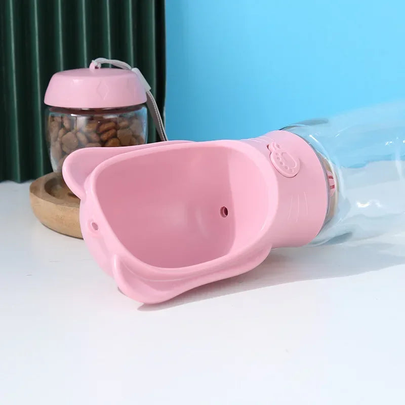 a pink pig shaped water bottle next to a glass