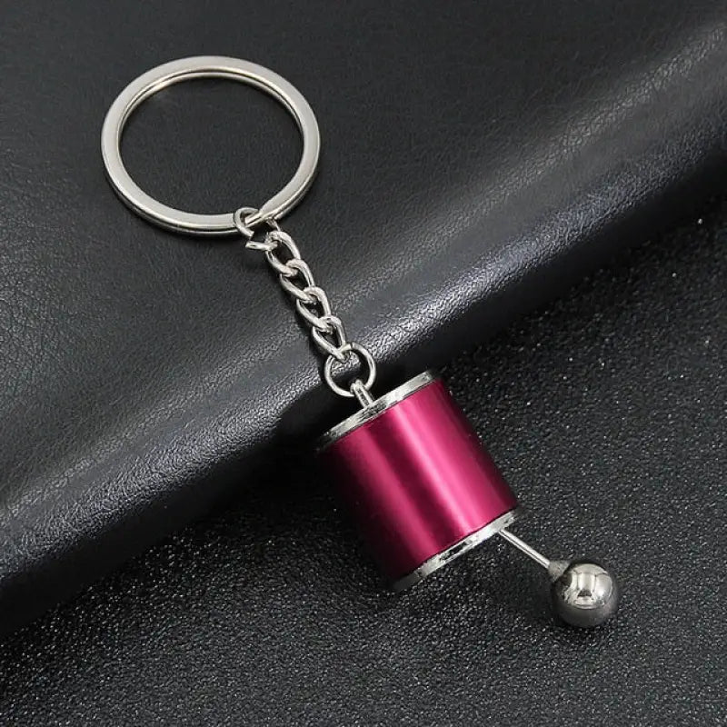 a close up of a metal keychain with a ball on it