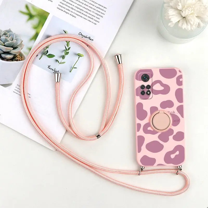a pink and white phone case with a pink cow print