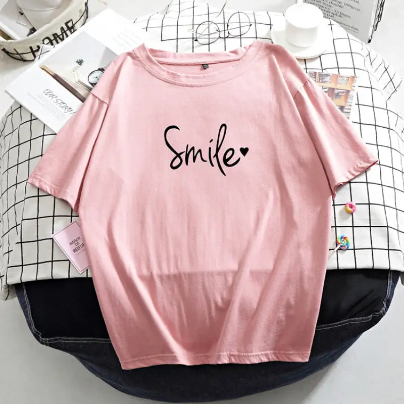 a pink shirt with the word smile on it