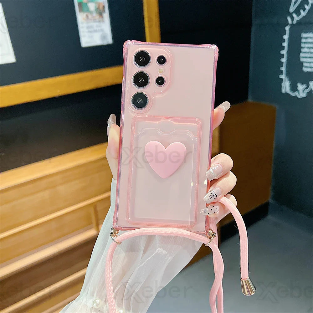 Pink smartphone case with a heart-shaped design and shoulder strap.