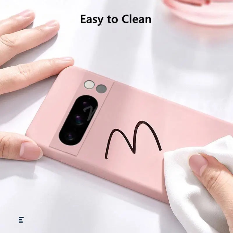 Pink smartphone case with a simple smiley face design and camera cutout.