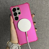 Pink smartphone in a clear case with a white circular wireless charger attached.