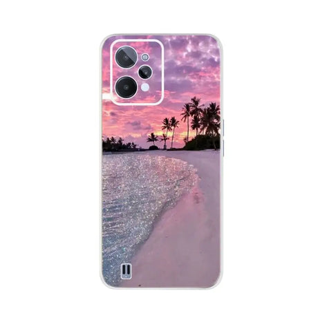 a pink sunset on the beach with palm trees and a clear sky