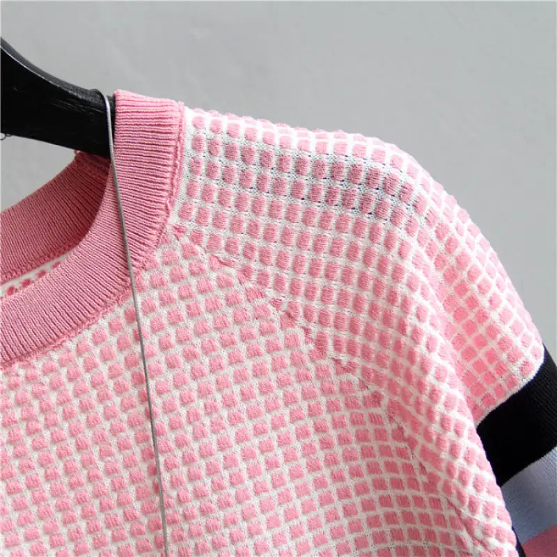 a pink sweater hanging on a hanger