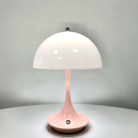 A pink table lamp on a white table