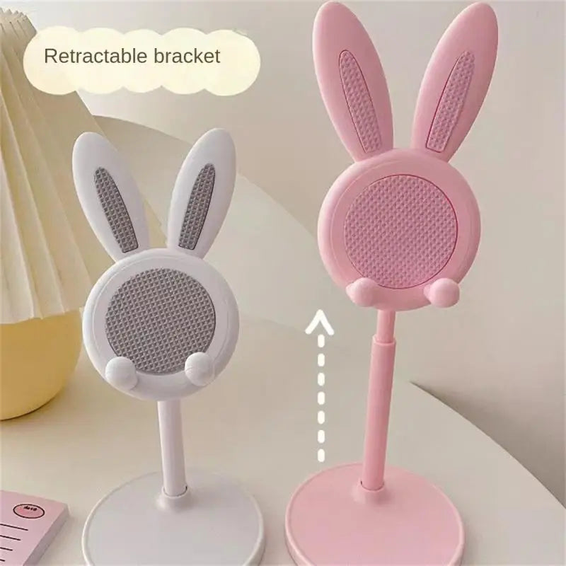 a pink and white rabbit shaped speaker on a table