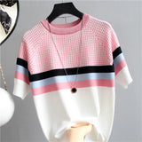 a pink and white sweater with a black and white checkered pattern