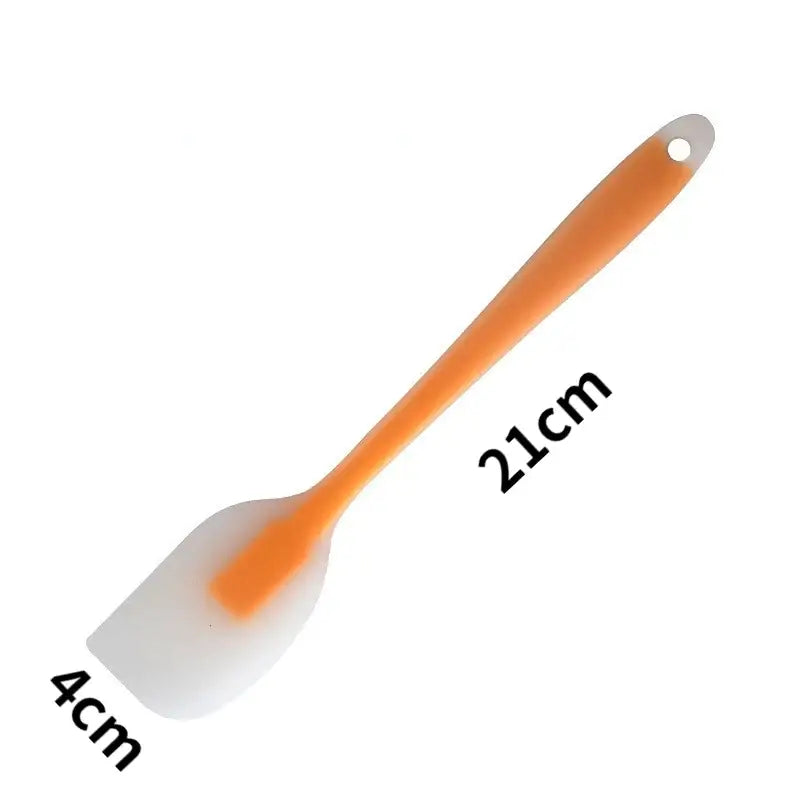 a plastic spat with a white handle and orange handle