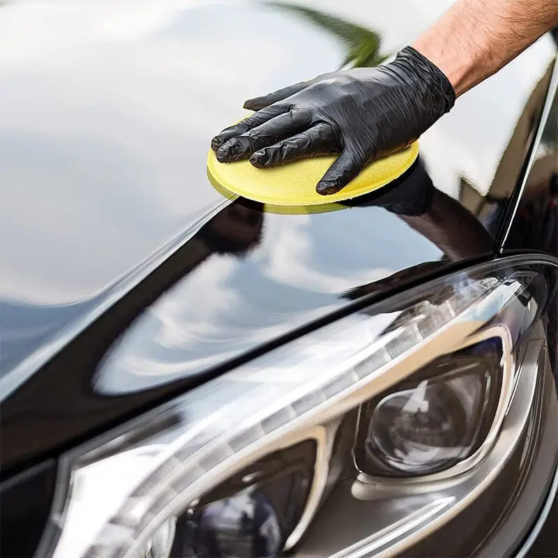 a man polishing a car with a sponge