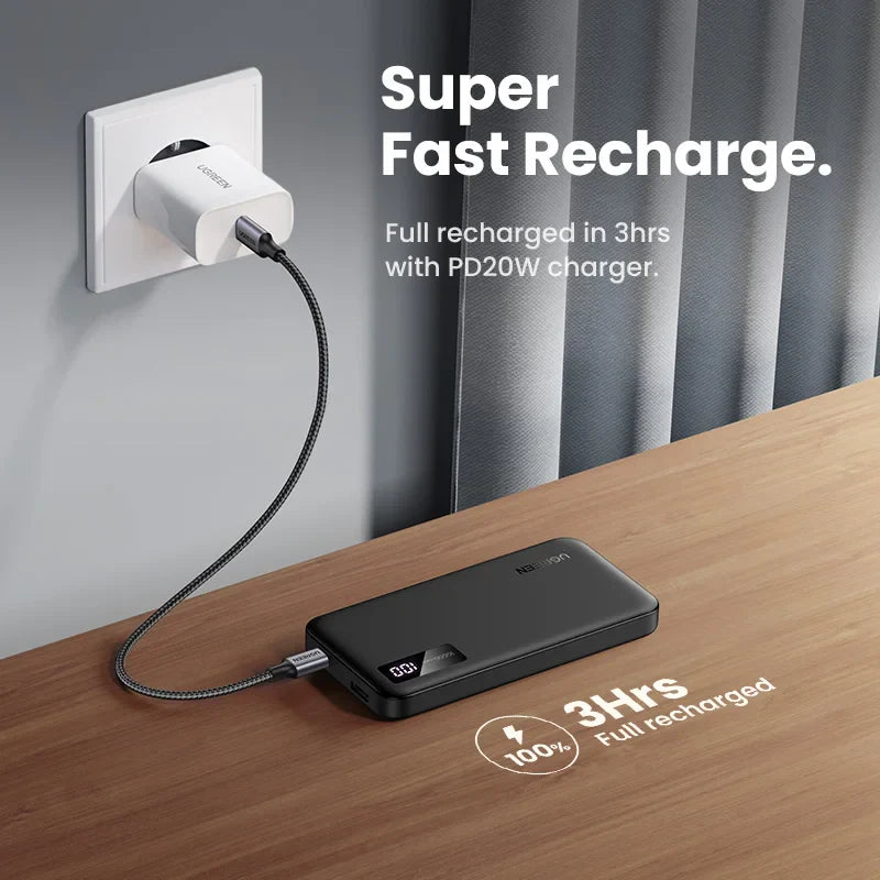 Portable battery pack connected to a wall charger via cable.