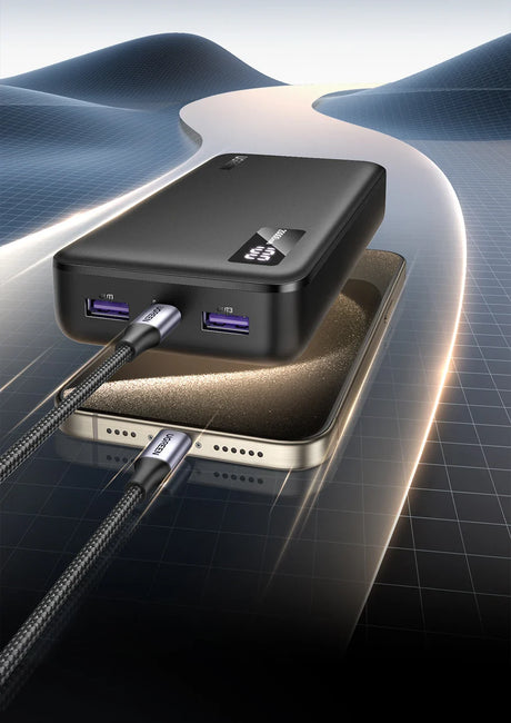 Portable battery pack or power bank with USB ports connected to a smartphone.