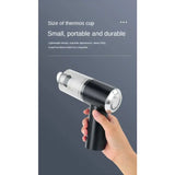 a hand holding a black and silver portable shower spray