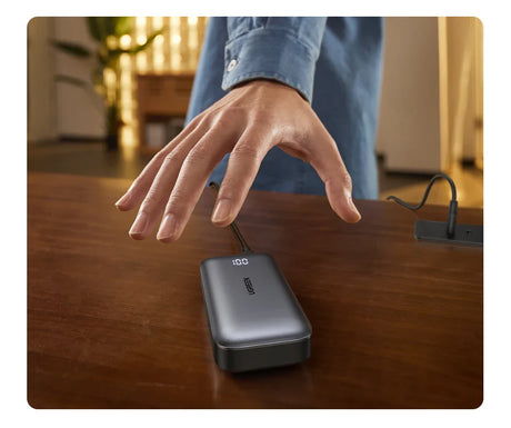 Portable external hard drive with a hand hovering above it.