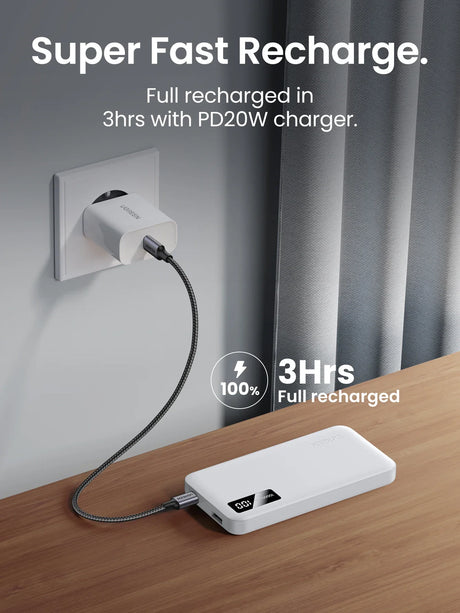 Portable power bank with a fast-charging cable plugged into a wall outlet.