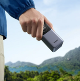 Portable power bank or external battery being held in a hand.