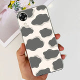 a woman holding a phone case with a cow print
