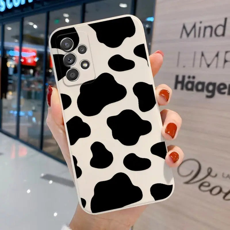 a woman holding a cell case with a cow print