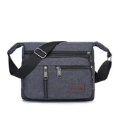 a grey cross body bag with a black strap and a black shoulder strap