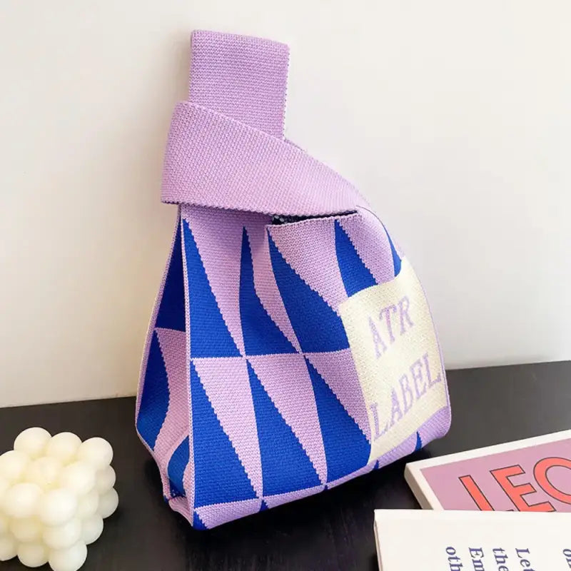 a purple and blue bag with a book on it