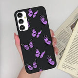 a woman holding a phone case with purple butterflies on it