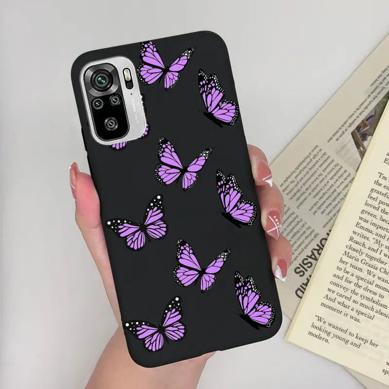 a woman holding a phone case with purple butterflies on it