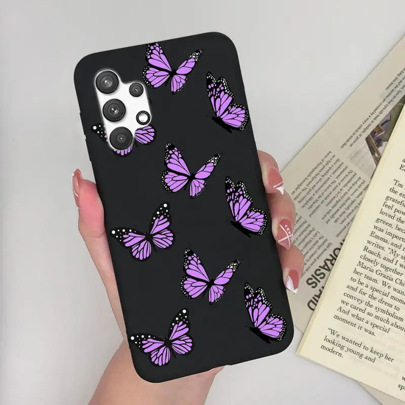 a woman holding a phone case with purple butterflies on it