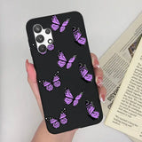 a woman holding a phone case with purple butterflies on it