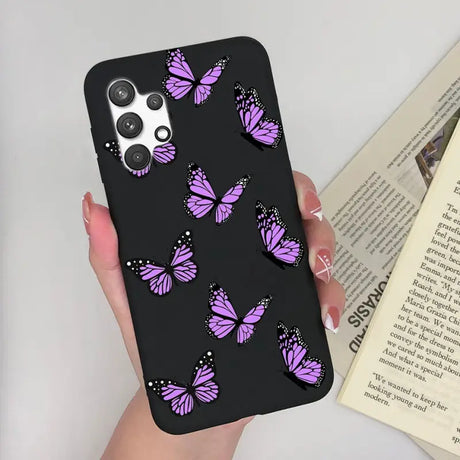 a woman holding a phone case with purple butterflies on it