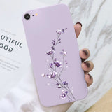 a woman holding a purple phone case with a flower design