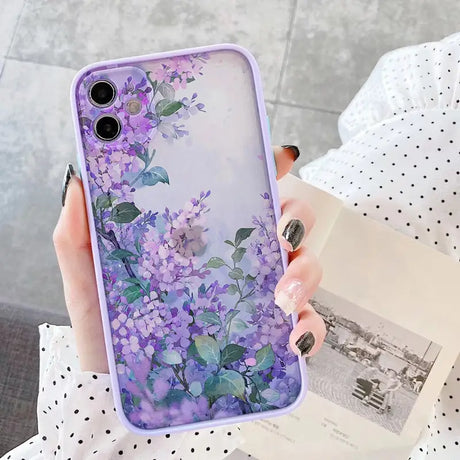 a woman holding a purple phone case with flowers on it