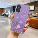 a woman holding a purple phone case with heart charms