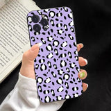 a woman holding a purple leopard print phone case