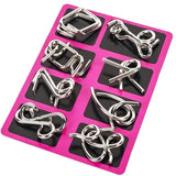 a set of six silver metal rings on a pink tray