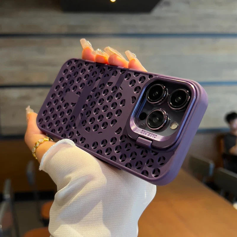 Purple perforated phone case with a triple camera cutout, held by a hand with orange-painted nails.