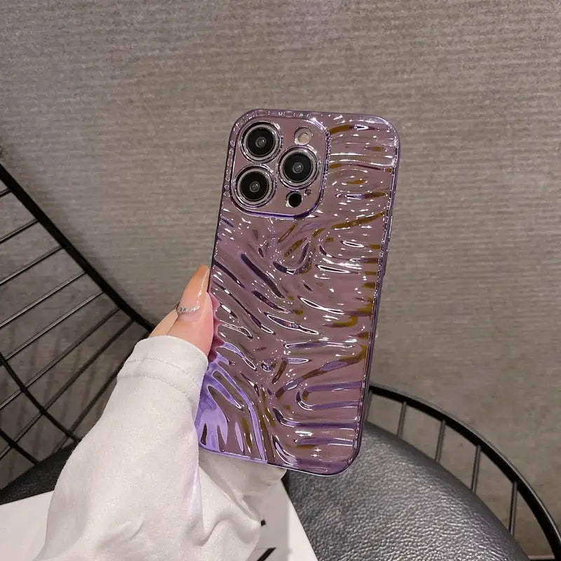 someone holding a purple phone case with a swirl design