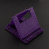 a purple plastic object on a black surface