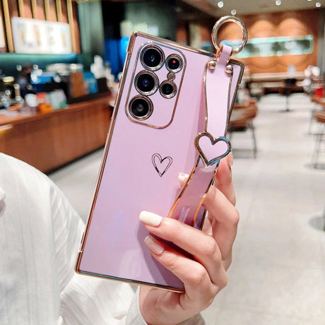 Purple smartphone with a gold-trimmed case and heart-shaped strap.