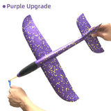 a hand holding a purple and gold glitter airplane