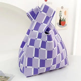 a purple and white bag sitting on a table