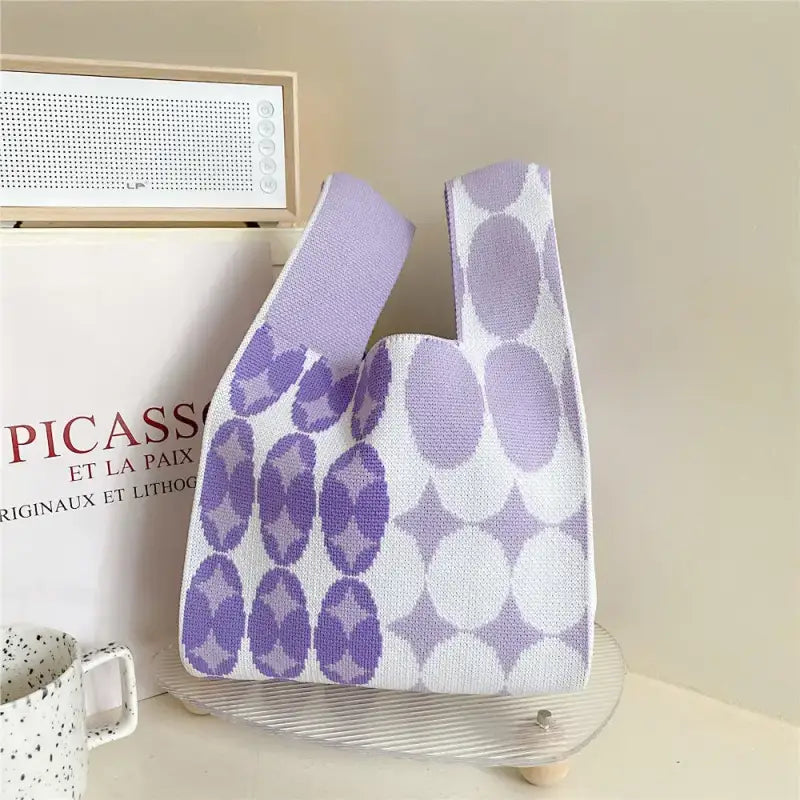 a purple and white bag sitting on top of a table