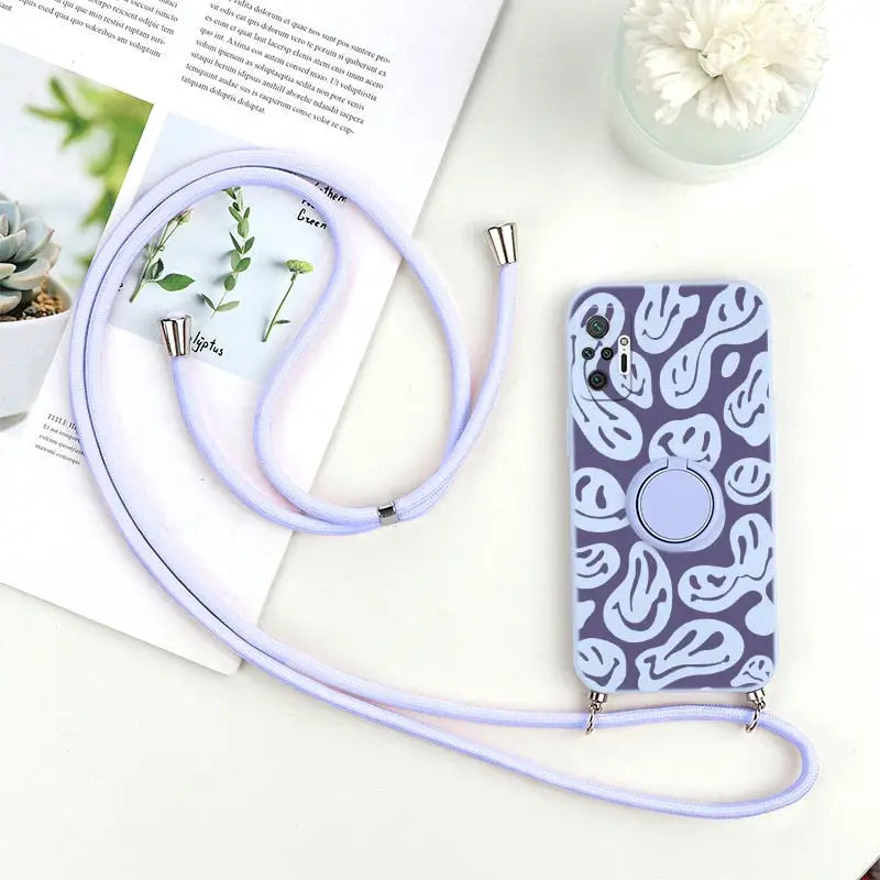 purple phone case with a strap and a flower on a table