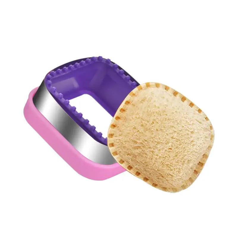 A purple and white sandwich cutter with a purple handle