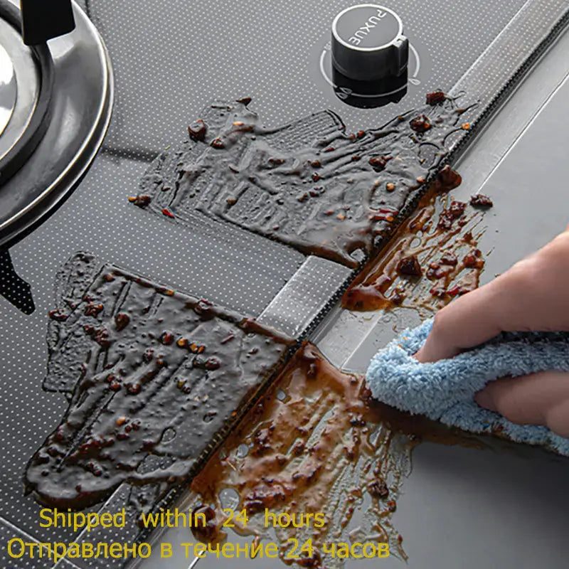 a person is cleaning a stove with a cloth