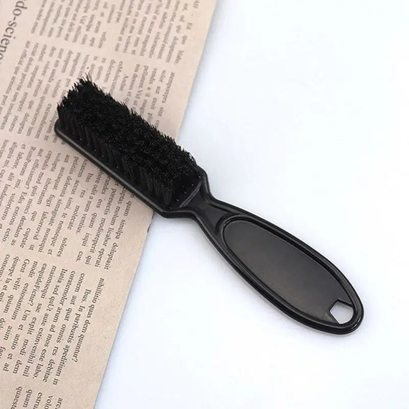 a black brush sitting on top of a newspaper