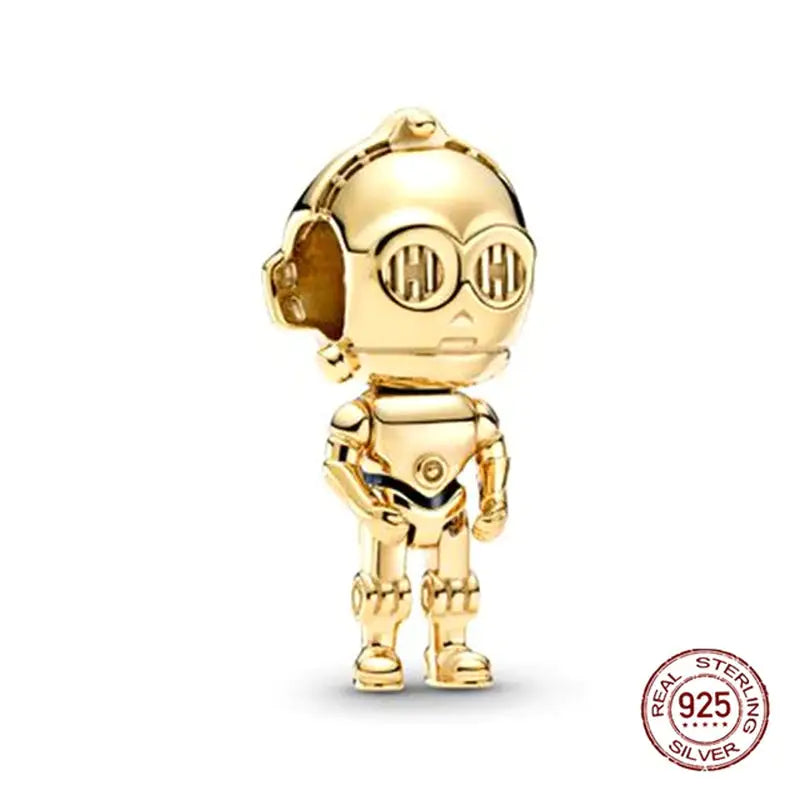 a gold charm with a small robot on it