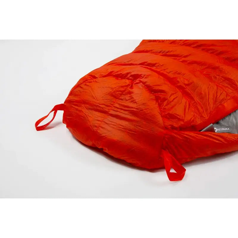 a red sleeping bag on a white surface