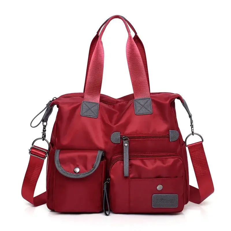 a red bag with a zippered pocket and a strap