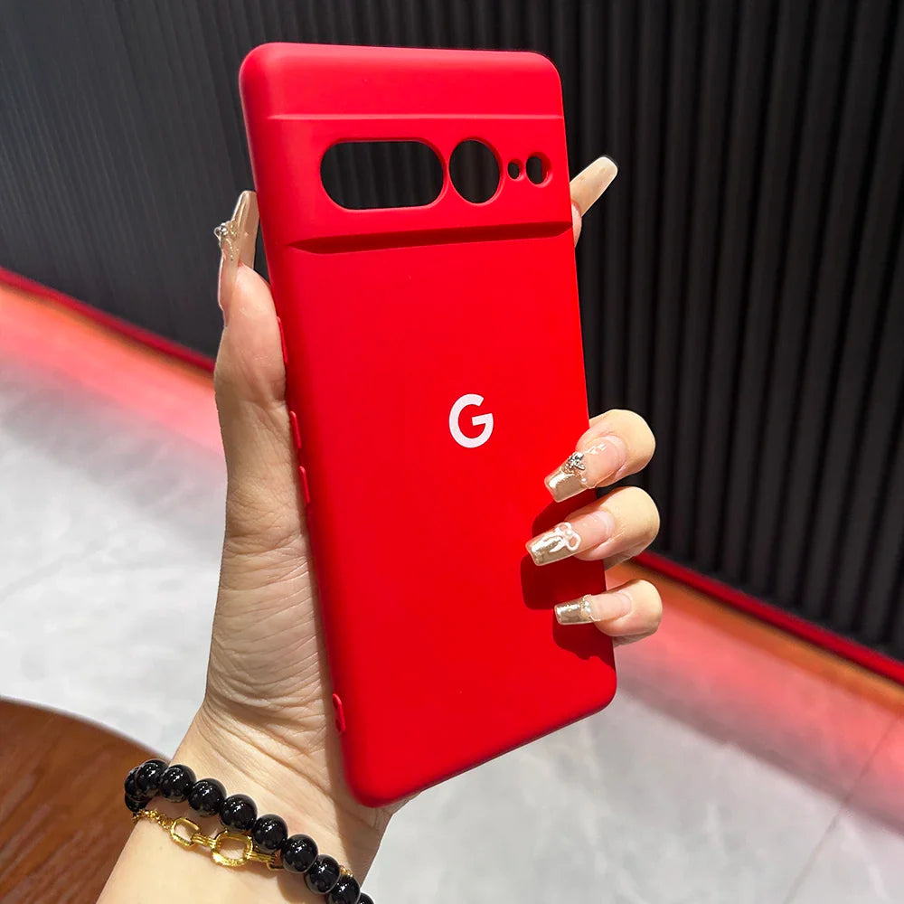 Red Google Pixel smartphone held in a hand wearing a dark beaded bracelet.