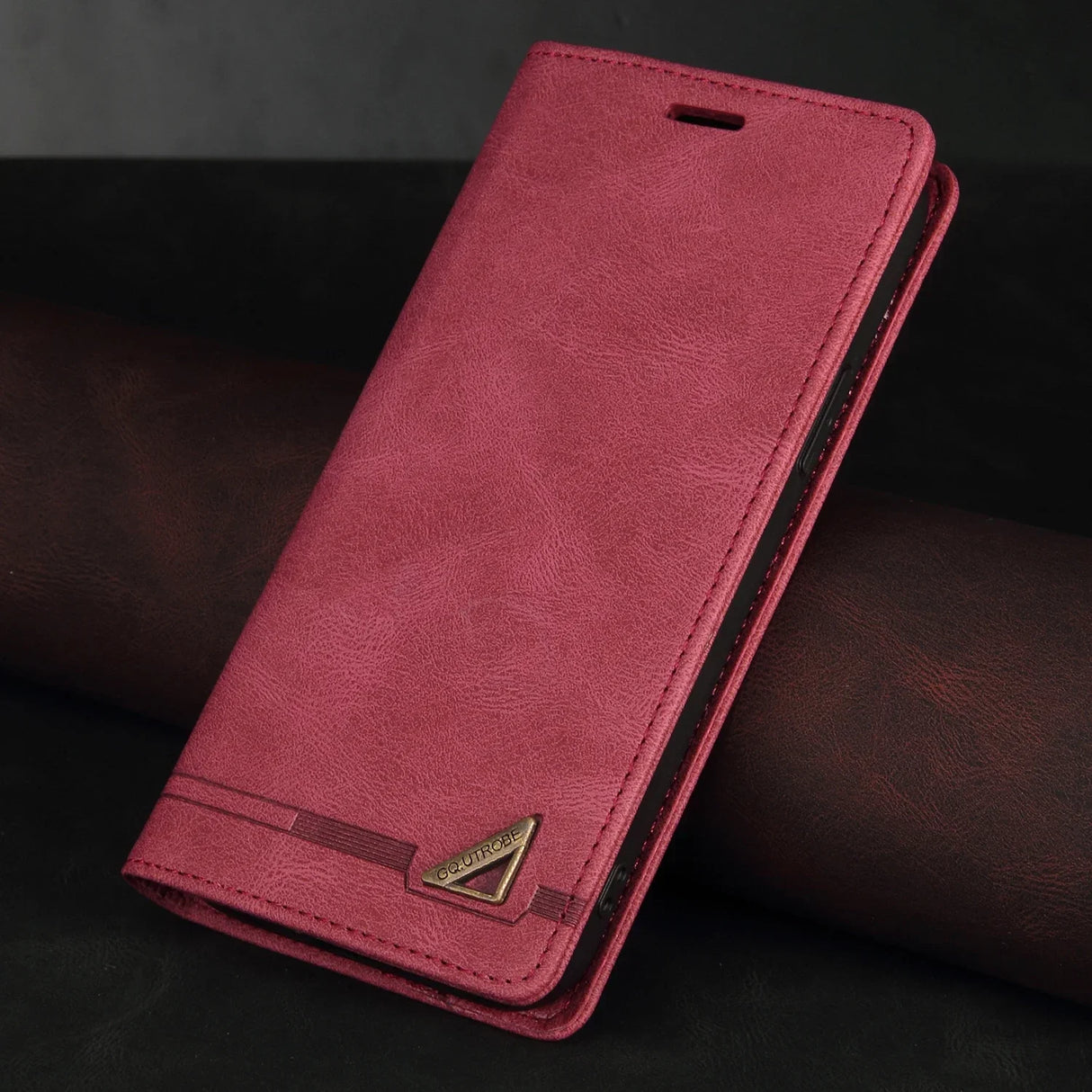 Red leather wallet-style phone case with a decorative metal accent.